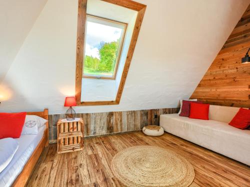 a attic room with a couch and a window at Gościniec Rabe - Agro&SPA in Ustrzyki Dolne