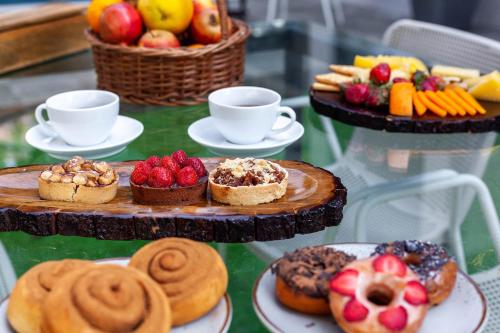 a table topped with plates of pastries and fruit at StayVista's Le Sutra Great Escapes - Udaan - Artistic Rooms, Terrace Jacuzzi with Scenic View in Lonavala