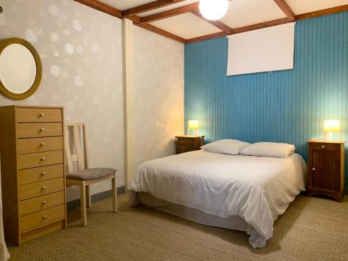 1 dormitorio con cama, tocador y espejo en Appartement WOAN centre Marciac, en Marciac