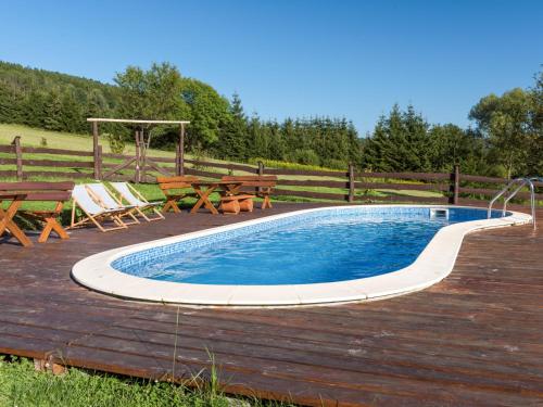 a pool on a deck with benches and a picnic table at Gościniec Rabe - Agro&SPA in Ustrzyki Dolne
