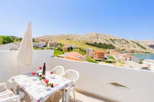 a white balcony with a table and chairs and a view at Magdalena with mountain and seaview in Metajna