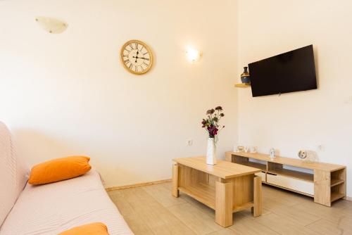 a living room with a couch and a clock on the wall at Magdalena with mountain and seaview in Metajna
