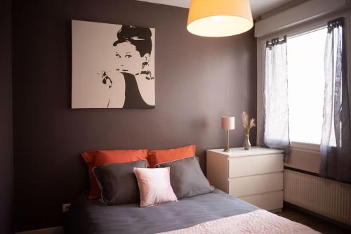 een slaapkamer met een bed en een schilderij aan de muur bij T2 Cosy & moderne avec Parking Privé Gratuit à Villeurbanne in Villeurbanne