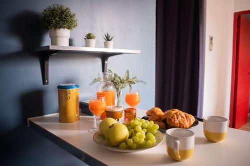 een tafel met een schaal fruit en sinaasappelsap bij T2 Cosy & moderne avec Parking Privé Gratuit à Villeurbanne in Villeurbanne