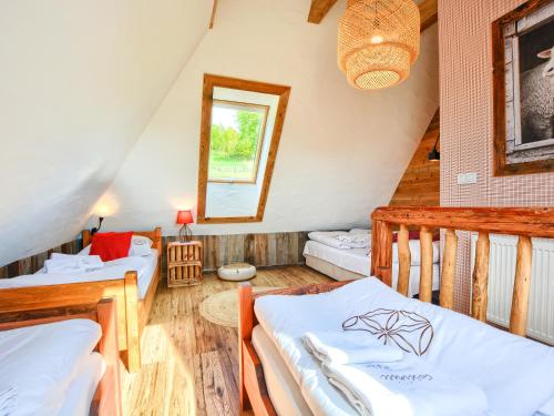 a attic room with two beds and a window at Gościniec Rabe - Agro&SPA in Ustrzyki Dolne
