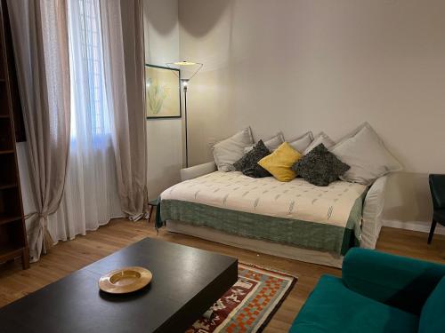 a living room with a bed with pillows on it at HouSmart Senzanome 9/3 in Bologna