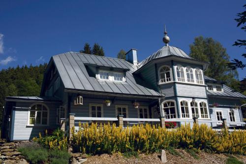 a large blue and white house with a turret at Penzion Modrý Pavilon in Dolní Malá Úpa