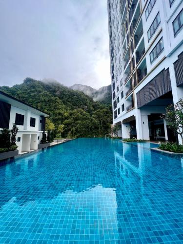 a large blue swimming pool next to a building at 2-8pax Ipoh Nomado Onsen suites by Sunway Onsen Lost world of Tambun in Ipoh