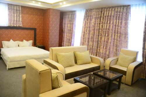Sadaf Hotel in Herat في هرات: غرفه فندقيه بسرير واريكه وكراسي