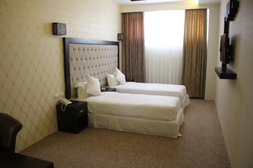 una camera d'albergo con due letti e un telefono di Sadaf Hotel in Herat ad Herāt
