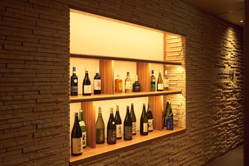 a shelf with bottles of wine on a brick wall at Sansuiso Tsuchiyu Spa in Fukushima