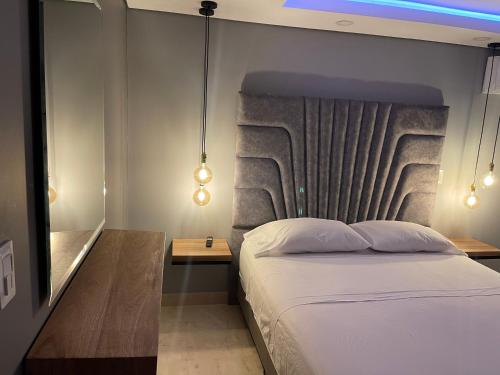 Schlafzimmer mit einem Bett mit Kopfteil und Beleuchtung in der Unterkunft Soho Deluxe in Medellín