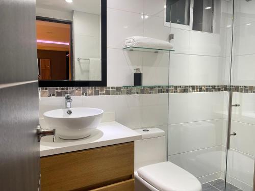 ein weißes Bad mit einem Waschbecken und einem WC in der Unterkunft Soho Deluxe in Medellín