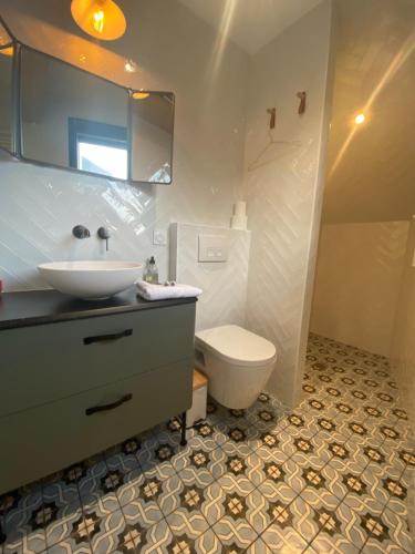 a bathroom with a sink and a toilet in it at La Suite du Héron nantais in Nantes