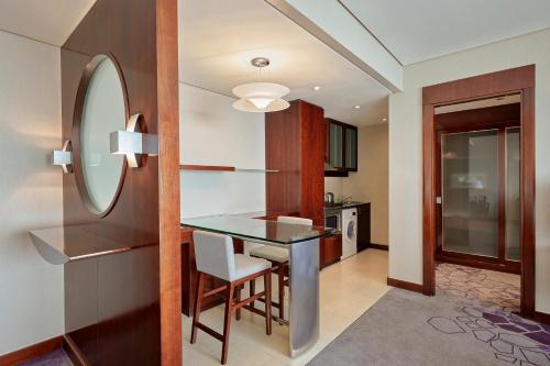 a kitchen and dining room with a table and a mirror at Rose Rayhaan by Rotana - Dubai in Dubai