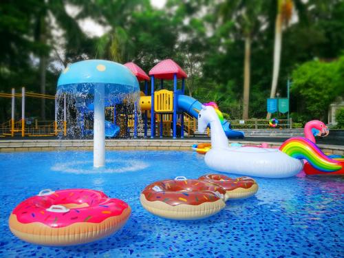 a pool with three inflatable flamingos and a water park at Mission Hills Hotel Resorts Dongguan in Dongguan