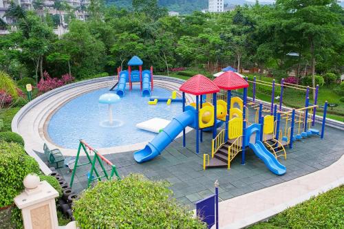 a pool with a playground with a slide in a park at Mission Hills Hotel Resorts Dongguan in Dongguan