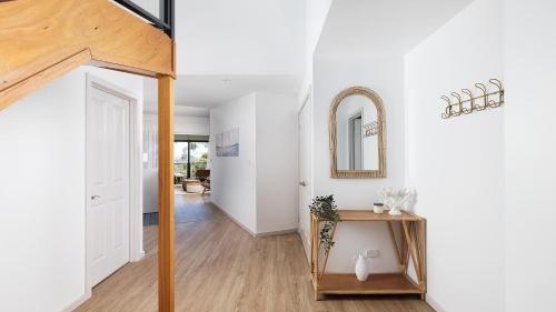 a hallway of a home with white walls and wood floors at Seascape Retreat - Magnificent 5 Bedroom Home in Nelson Bay