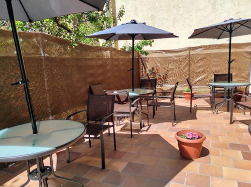 サント・トメ・デル・プエルトにあるApartamentos Turísticos La Casa de Dafneのテーブルと椅子とパラソルのあるパティオ