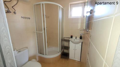 a bathroom with a shower and a toilet and a sink at Apartament Rybacka 84/9 in Krynica Morska - Piaski