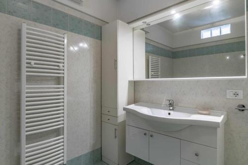 La salle de bains est pourvue d'un lavabo et d'un miroir. dans l'établissement Appartamento al nido Grauno OSPITAR, à Grauno