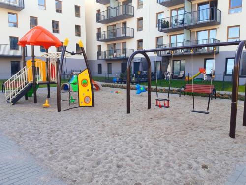 plac zabaw na piasku przed budynkiem w obiekcie Apartament Kapitalny przy porcie w Kołobrzegu z rowerownią i placem zabaw w Kołobrzegu