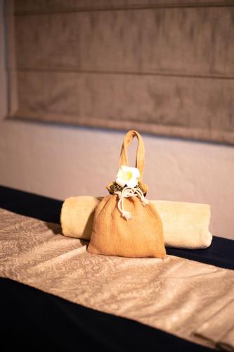 a tan purse sitting on top of a bed at The Baagh Ananta Elite Ranthambore in Sawāi Mādhopur