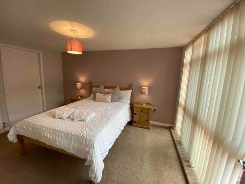 een slaapkamer met een wit bed en een raam bij Cosy Homely Apartment close to Lincoln City Centre in Lincoln