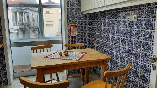 Ein Tisch und Stühle in einem Raum mit blauen Fliesen in der Unterkunft taol in Vila Nova de Gaia