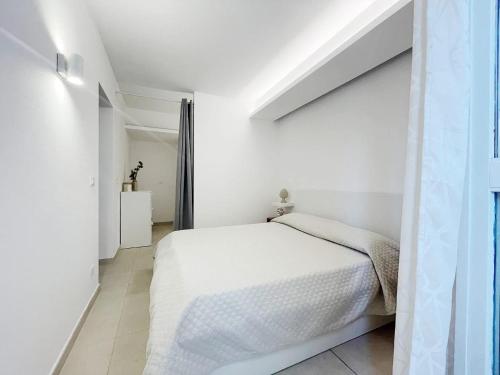 ein weißes Schlafzimmer mit einem Bett und einem Fenster in der Unterkunft Casa Vacanze Margherita in Castellammare del Golfo