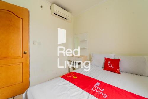 um quarto com uma cama com um cobertor vermelho em RedLiving Apartemen Mediterania Palace - Meditrans Property Tower B em Jakarta