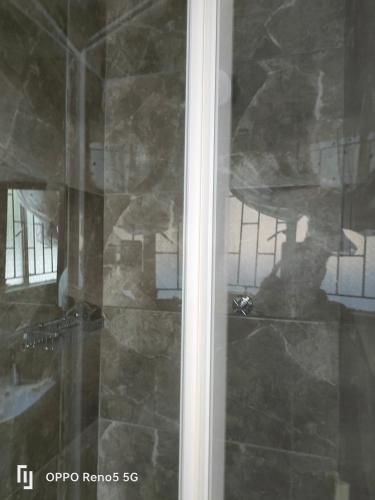 a glass door with a reflection of a person in a room at Kea bed and breakfast in Mogwase