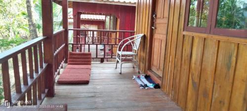 a porch of a house with a chair and a rug at Sok Mean Bungalows in Koh Rong Sanloem