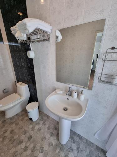 La salle de bains est pourvue d'un lavabo, de toilettes et d'un miroir. dans l'établissement MonMin Farmstay, à Ban Mae Cho