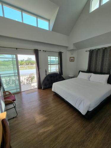 Ban Mae Cho的住宿－MonMin Farmstay，卧室设有白色的床和大窗户