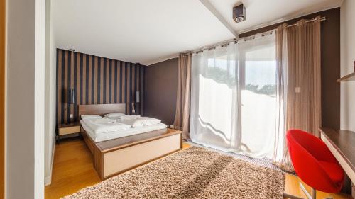a bedroom with a bed and a large window at Wczasowa Apartamenty Południowe, Sun & Snow in Ustka