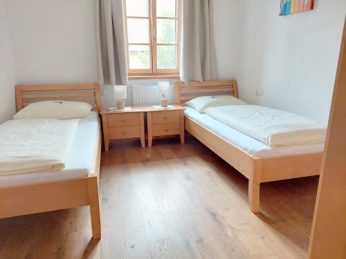 2 Einzelbetten in einem Zimmer mit Fenster in der Unterkunft Weslhof in Attersee am Attersee