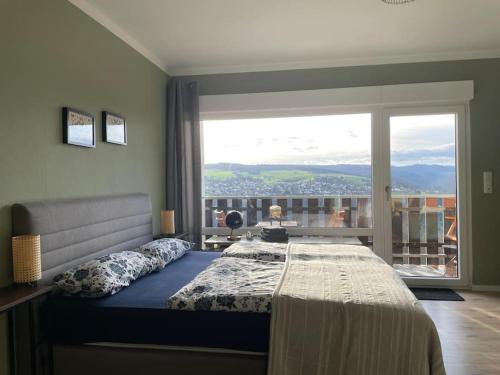 1 dormitorio con cama y ventana grande en #1 Studioapartment mit Loreleyblick direkt an der schönsten Etappe des Rheinsteigs en Patersberg