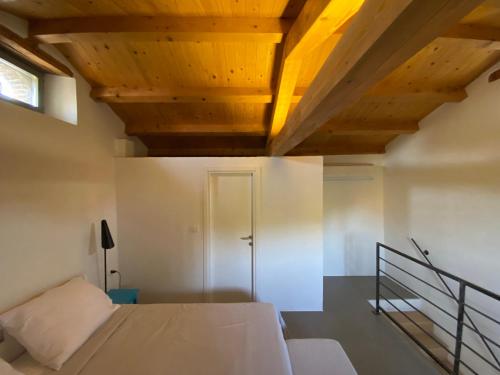 1 dormitorio con cama y techo de madera en Charmantes Ferienhaus mit Pool und Garten-Villa Šterna II, en Kaštelir