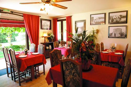 une salle à manger avec tables et chaises et nappes rouges dans l'établissement Longo Mai, à Le Sambuc