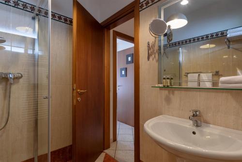 デセンツァーノ・デル・ガルダにあるIl Sogno Apartmentsのバスルーム(洗面台、ガラス張りのシャワー付)