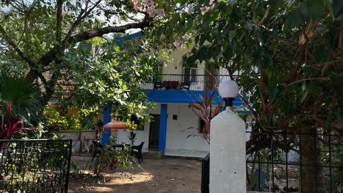 a white and blue building with a balcony at Muffys Holiday Home in Old Goa