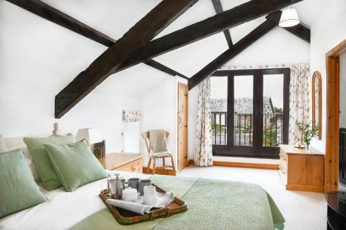 una camera da letto con un letto e una grande finestra di Downe Cottages a Hartland
