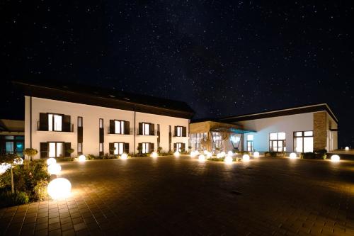 a large building with a parking lot at night at Crama Jelna Resort & Spa in Orheiu Bistriţei
