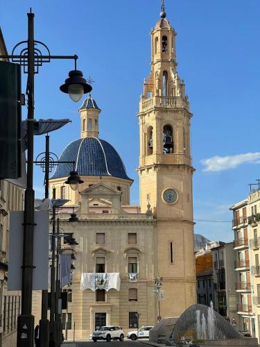 a large building with a clock tower in a city at Piso en el centro de Alcoy para sentirte en casa in Alcoy