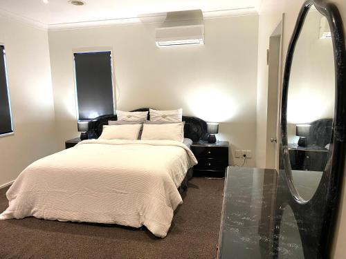 a bedroom with a bed and a large mirror at Luxury 5beds and 5bedroom in Lower Hutt