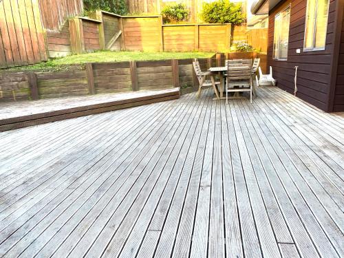 a wooden deck with a table and chairs on it at Luxury 5beds and 5bedroom in Lower Hutt