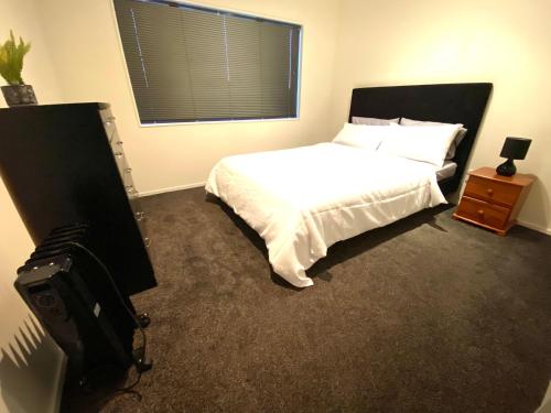 a bedroom with a bed and a television in it at Luxury 5beds and 5bedroom in Lower Hutt