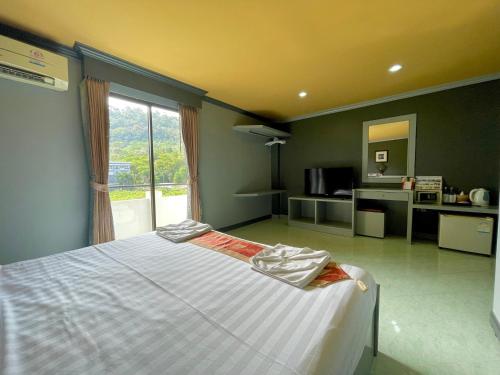 a bedroom with a bed and a large window at The Little Moon Residence in Patong Beach