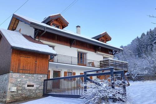 a house with snow on the ground in front of it at Gîte Cœur de Haute-Savoie in Viuz-en-Sallaz